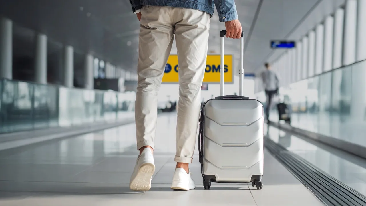 A traveller pulling a suitcase through an airport